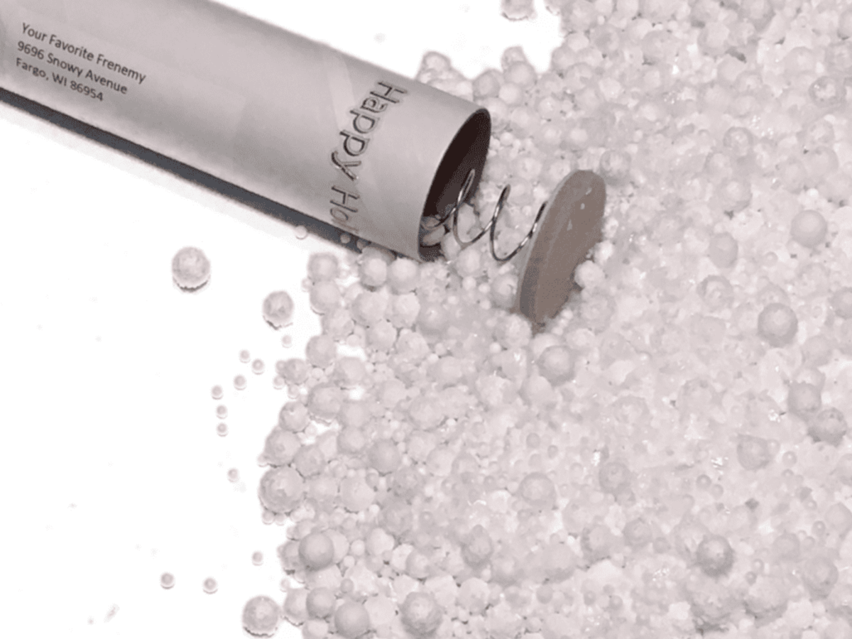Open spring-loaded snow bomb filled with snow confetti.